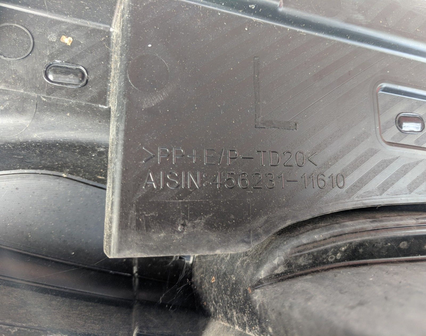 Close-up of 2012-2017 Toyota Prius C Front Windshield Cowl Panel Top Assembly 456231-11610 with visible part number engravings.